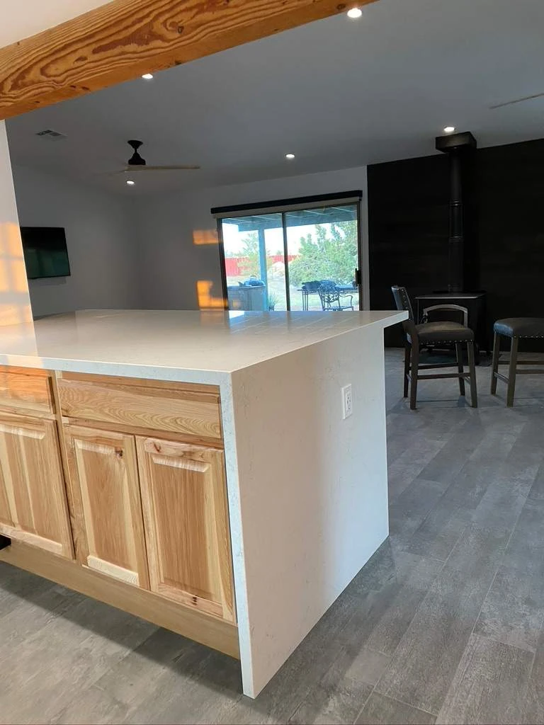 Kitchen island with custom wood cabinetry opening onto a living area