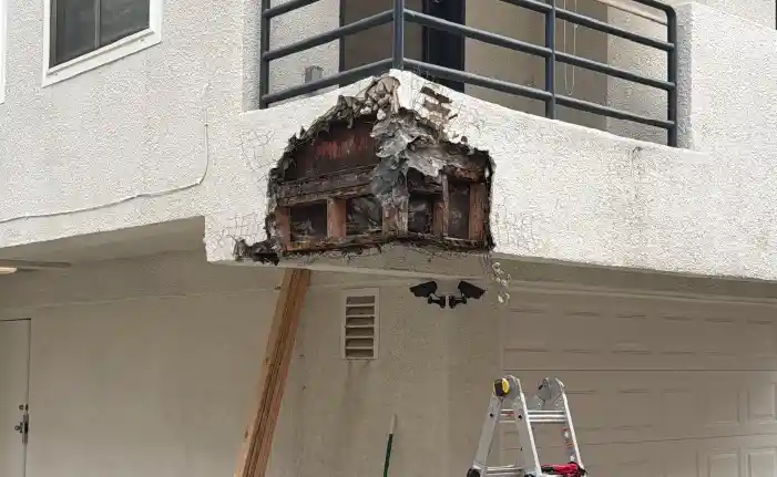 Rotted wood framing exposed under second-story balcony with temporary wood shoring post, Marina del Rey structural damage assessment