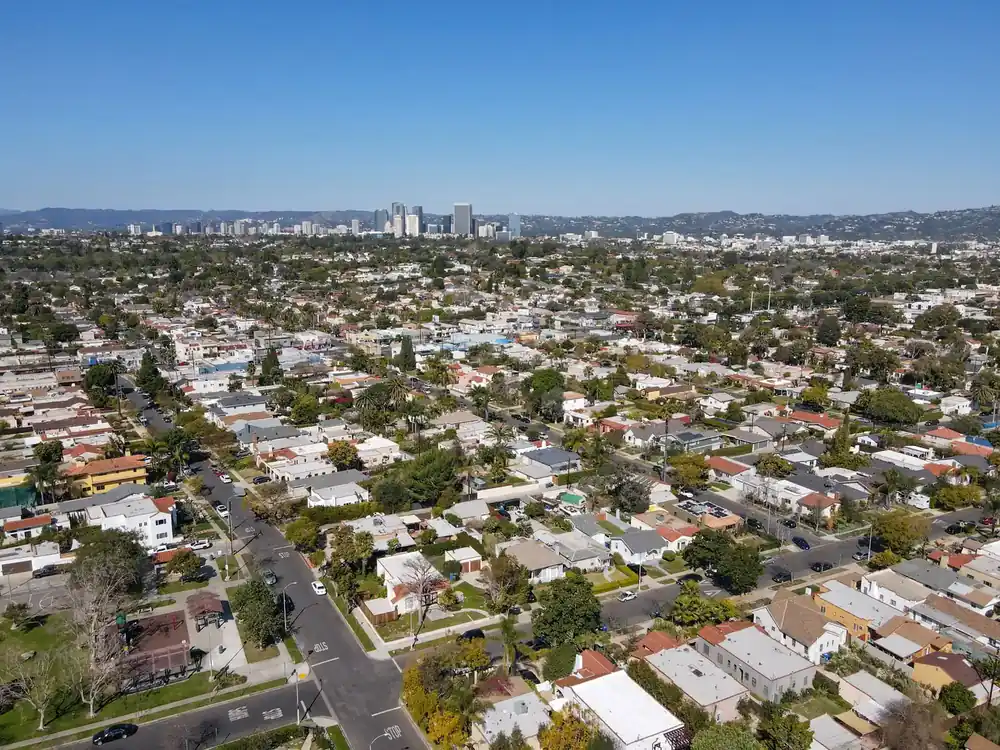 Wide aerial view of West Los Angeles, California, showcasing residential streets, mature neighborhoods, and the surrounding Westside skyline.