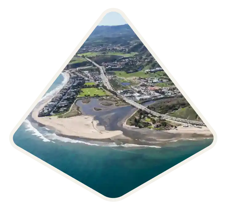 Aerial view of the lagoon, surf and Pacific Coast Highway curving along the shore in Malibu, CA