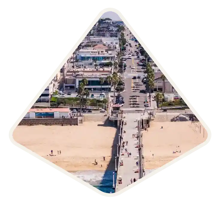 The pier and beachfront homes seen from above the sand in Manhattan Beach, CA