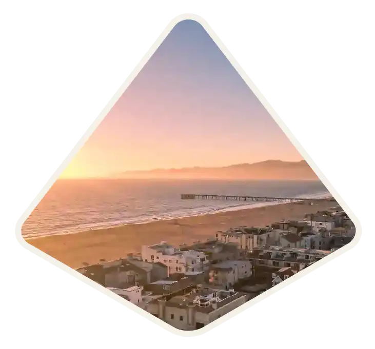 Sunset over the beach and fishing pier looking along the shoreline in Venice, CA
