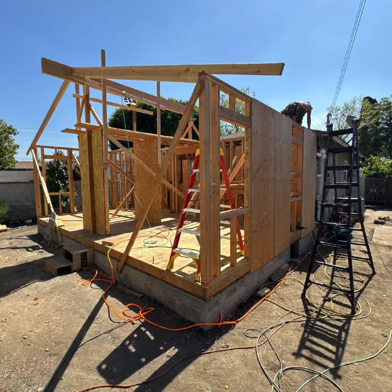 Timber-framed ADU under construction on a poured concrete slab at a Los Angeles job site